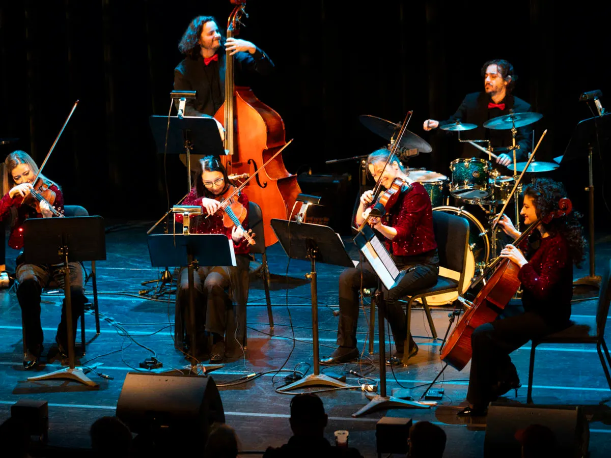 La photo montre le groupe de musiciens et musiciennes sur scène