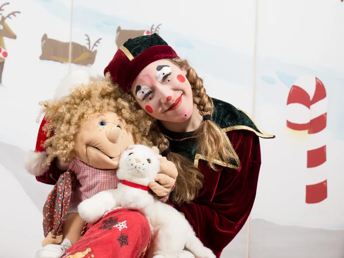 Une comédienne maquillée tient dans ses mains une marionette.