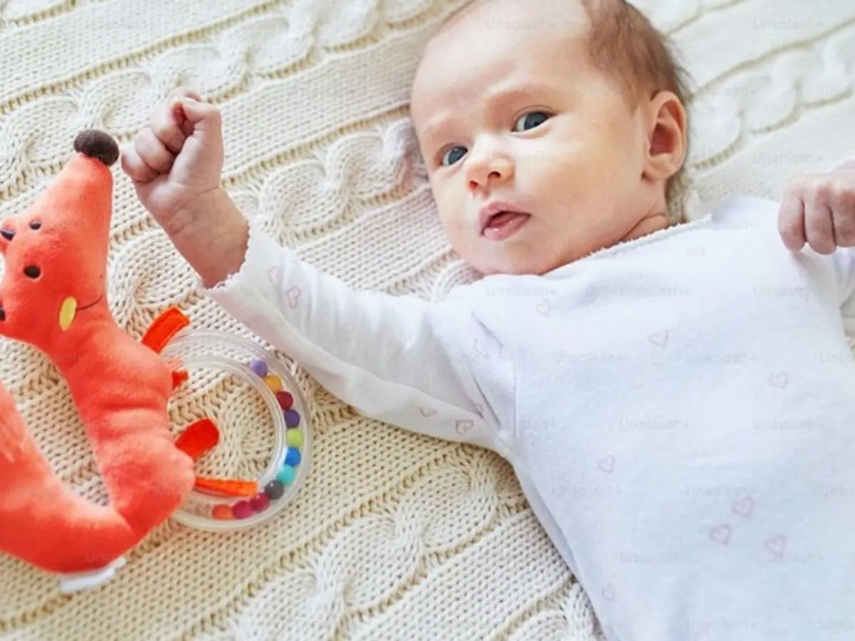Photo d'un bébé couché avec une peluche