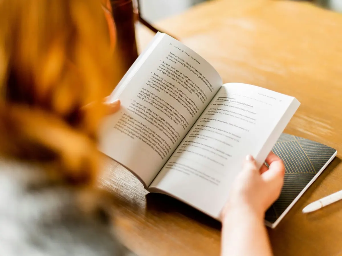 Photo d'une personne avec la peau claire qui pagine un livre