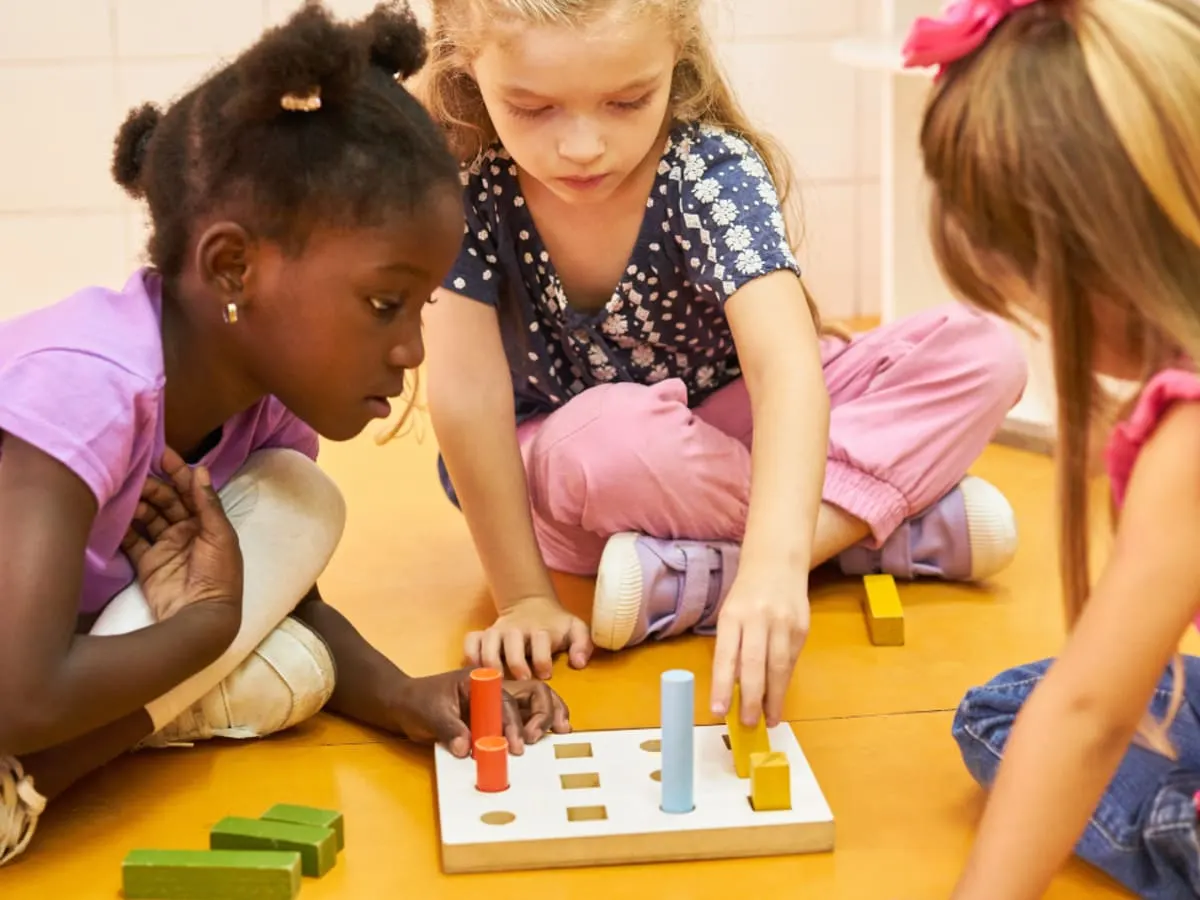 Photographie de trois enfants jouant à un jeu de société
