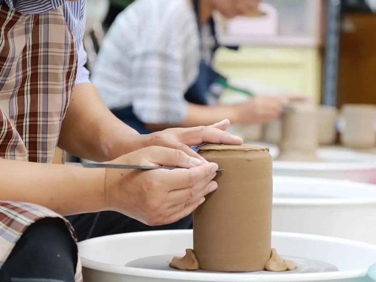 Photo d'une personne en train de confectionner un pot en céramique