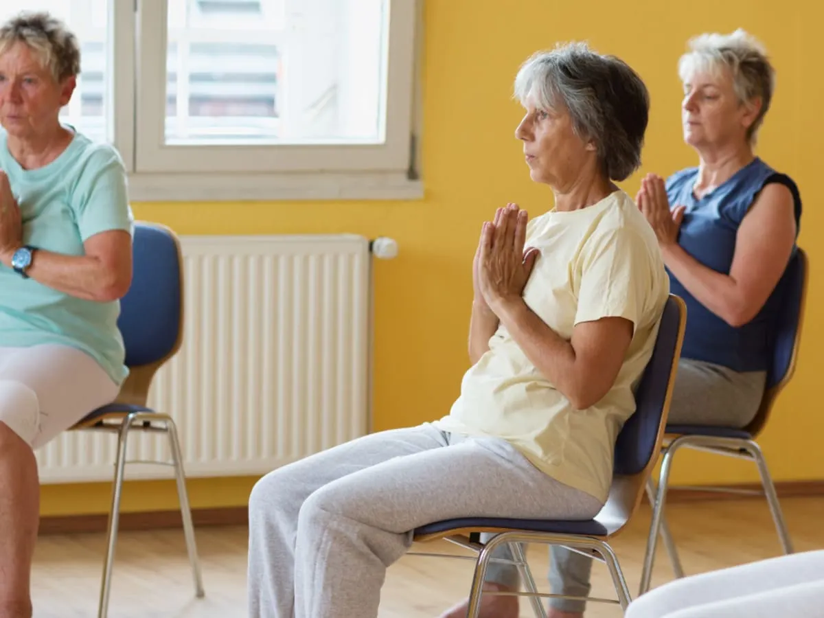 Personnes en train de faire du yoga sur chaise